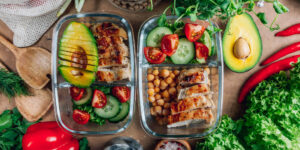 Lunch box compartimentée ouverte avec un repas préparé, posée sur une table